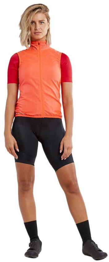 Dames Craft fietsvest in feloranje met ritssluiting, gecombineerd met een rood fietsjack en zwarte fietsbroek.