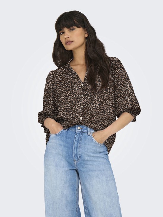 Model draagt een bruine blouse met luipaardprint, driekwart mouwen en lichtblauwe wijde jeans.