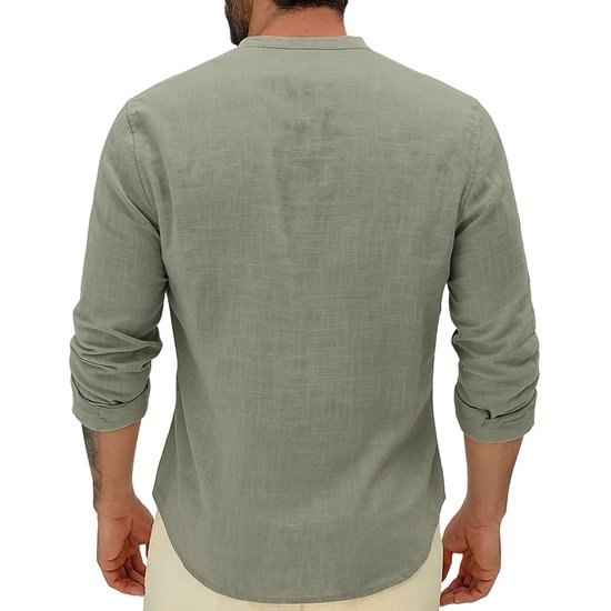 Man draagt een lichtgroene linnen blouse met lange mouwen, rugaanzicht, met handen in de zakken.