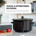 Zwarte Brabantia slowcooker met glazen deksel, in een moderne keukenomgeving.