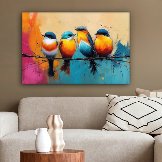 Vier kleurrijke vogels op een tak, hangend aan een muur boven een bank. De achtergrond is een abstracte mix van oranje, roze, blauw en geel.