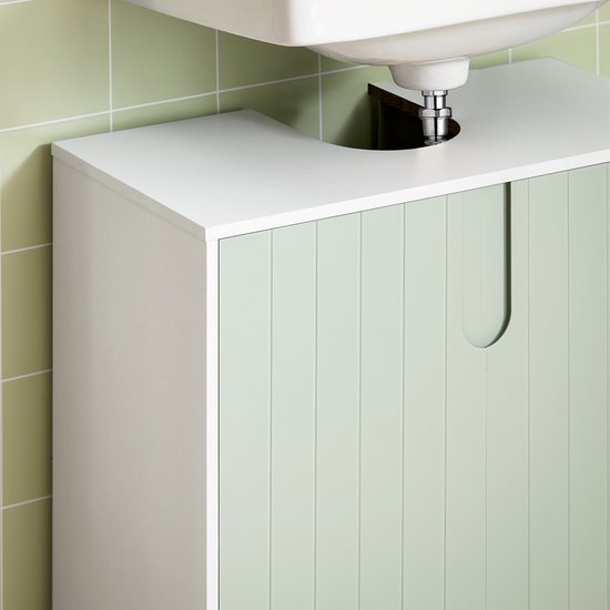 Zicht op een witte onderbouwkast met groene, gegroefde deuren onder een witte wasbak. De rand van de kast en de uitsparing zijn zichtbaar.