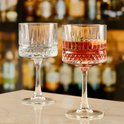 Twee glazen met rode drank, sinaasappel en rozemarijn.