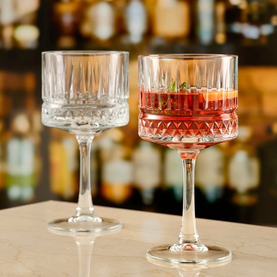 Twee glazen met rode drank, sinaasappel en rozemarijn.