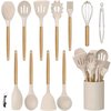 Set complet d'ustensiles de cuisine en silicone beige avec manches en bois, y compris un pot de rangement et une pince.