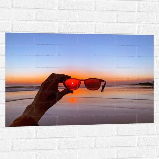 Muursticker - Strand - Zee - Water - zand - Zonsondergang - Hand -Bril - 90x60 cm Foto op Muursticker