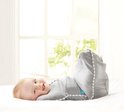 Baby in grijze Love to Dream™ Swaddle Up™ met witte strepen, liggend op de rug.
