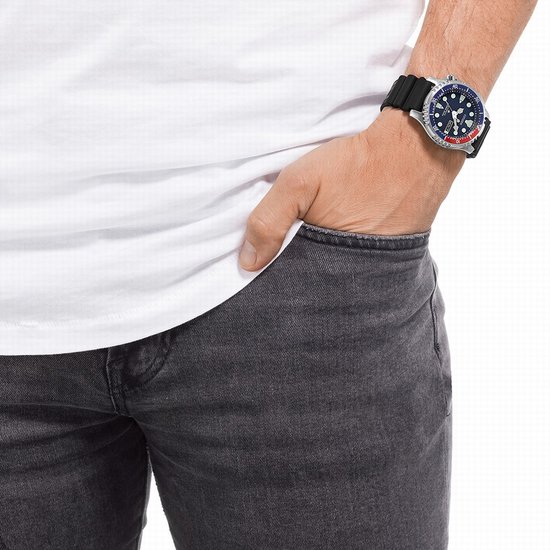 Man met een witte T-shirt en grijze jeans, draagt een Citizen Promaster duikhorloge.