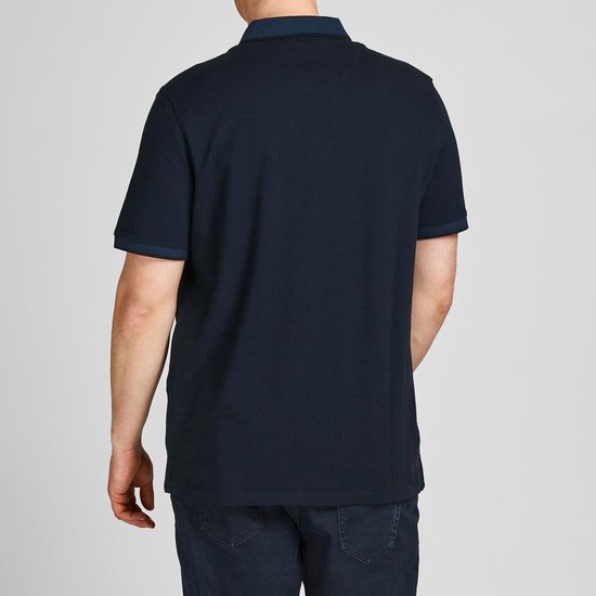 Man van achteren gezien, draagt een donkerblauw poloshirt.