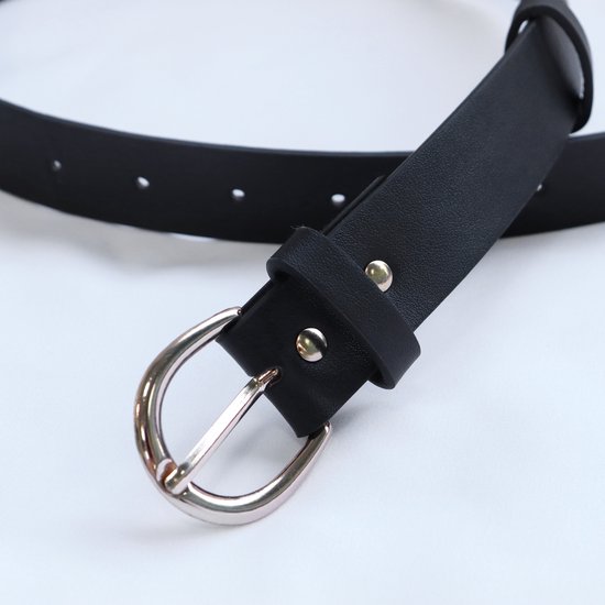 Gros plan sur la boucle d'une ceinture noire avec une boucle argentée.
