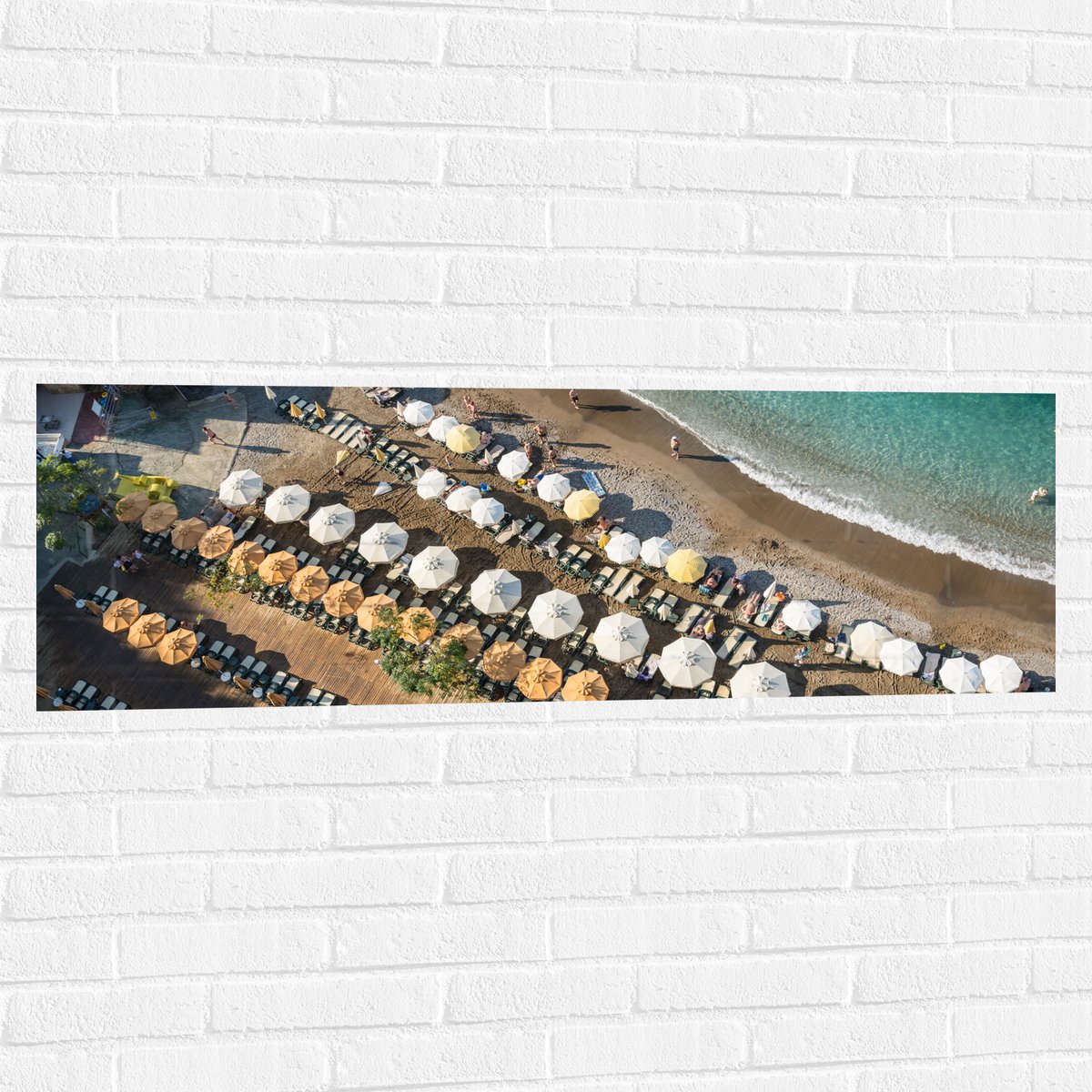 Muursticker - Zee - Strand - Bedjes - Parasols - Water - Hout - Mensen - 120x40 cm Foto op