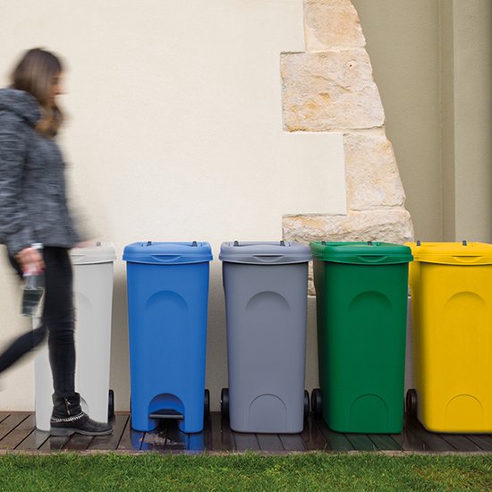 Vrouw loopt langs witte, blauwe, grijze, groene en gele kliko's.