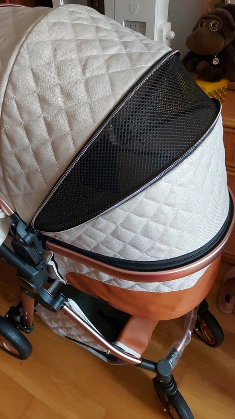 Lichtgrijze kinderwagen met gewatteerde kap en koperkleurige details. Een zwarte horrengaas opening in de kap.