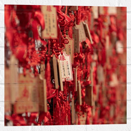 Muursticker - Rode Sleutelhangers met Chinese Tekens aan een Muur - 50x50 cm Foto op Muursticker