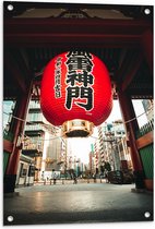Tuinposter – Mega Rode Lampion met Chinese Tekens in Grote Stad - 60x90 cm Foto op Tuinposter (wanddecoratie voor buiten en binnen)