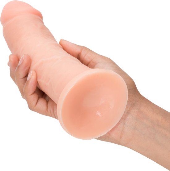 Un gode ceinture beige, à base large, tenu dans des mains. Le gode présente des veines réalistes.