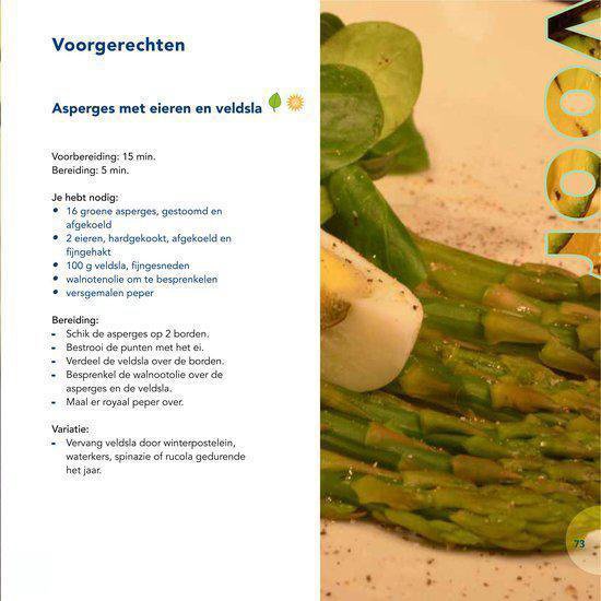 Een close-up van gestoomde groene asperges met een hardgekookt ei en veldsla.
