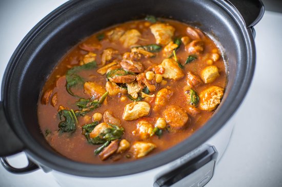 Close-up van stoofpot met kip, chorizo, kikkererwten en spinazie in een Russell Hobbs slowcooker.