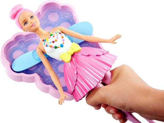 Barbie Dreamtopia zeemeermin met roze haar, witte top, roze rok en vleugels, vastgehouden door een hand die bubbels maakt.