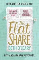 Boekomslag van 'The Flat Share' met opgemaakt bed, kussens met tekst en titel in goud.