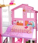Bovenste verdieping van een Barbiehuis met een roze gestreept bed, oranje zitzak en een raam.