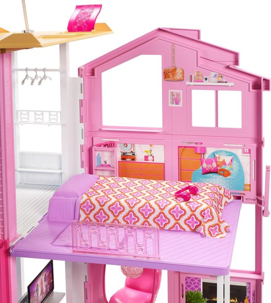 Bovenste verdieping van een Barbiehuis met een roze gestreept bed, oranje zitzak en een raam.