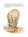 Een hondje met witte en bruine vlekken kijkt naar een olifant met bloemenversiering op zijn rug.