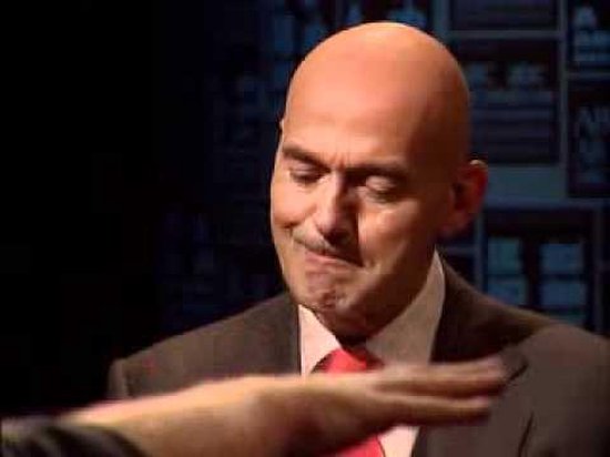 Een man met een kaal hoofd en een rood stropdas kijkt naar beneden.