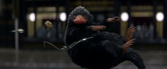 Een zwart, harig wezen met een roze snuit en klauwen, dat naar schatten grijpt.