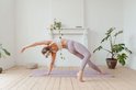 Vrouw in een yogapose op een lavendelpaarse mat met maanfasen.