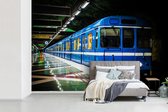 Behang - Fotobehang Donker metrostation met een blauwe trein - Breedte 360 cm x hoogte 240 cm