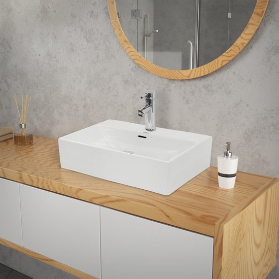 Élégante vasque blanche sur un meuble-lavabo en bois, avec un robinet brillant et un distributeur de savon.