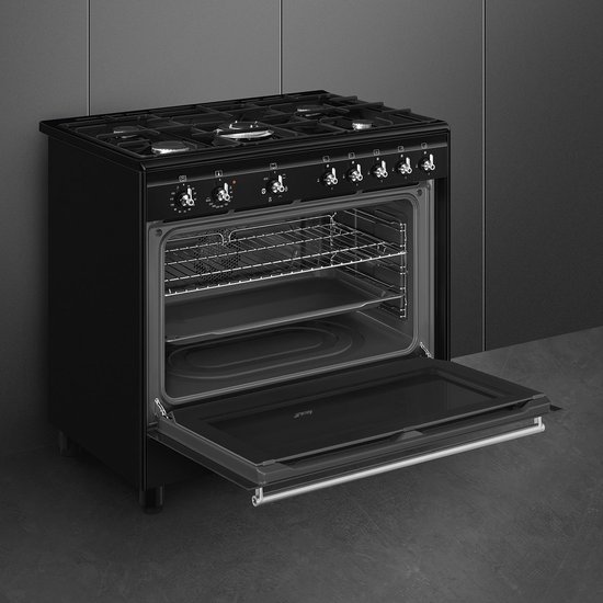 Zwart gasfornuis met open oven deur en roosters. De oven is leeg.