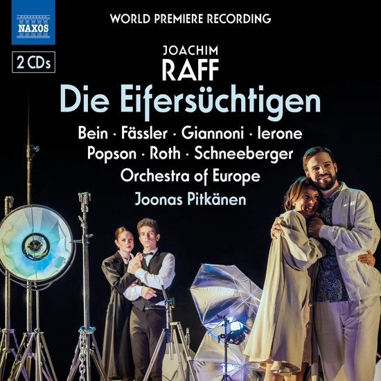 Jonge mensen omhelzen elkaar met een glimlach, met op de achtergrond een orkest en opnamespulen. "Die Eifersüchtigen" op Naxos.