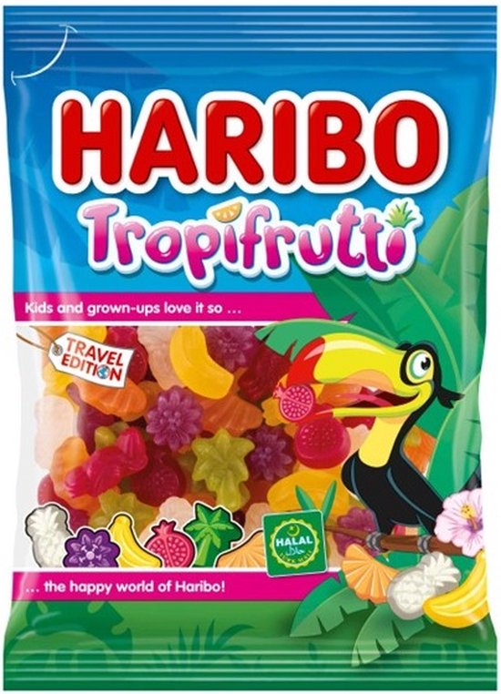 Haribo Tropifrutti zak met veelkleurig fruitig snoep, waaronder ananas-, banaan- en frambozenvormen. Een toekan en tropische bladeren sieren de verpakking.