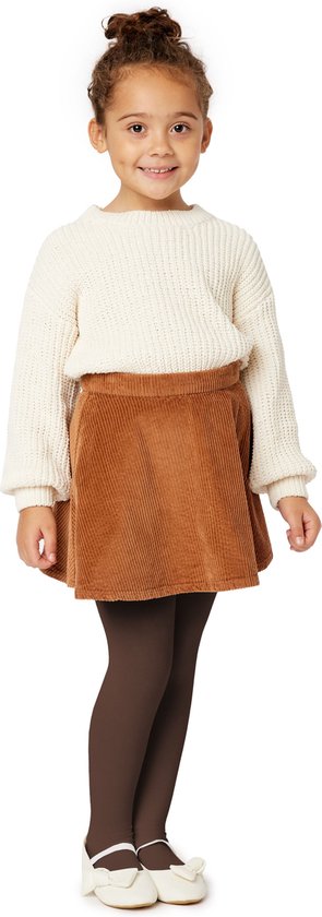 Meisje staand met bruine panty, witte trui en bruine corduroy rok.