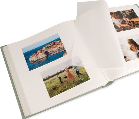 Open lichtgroen fotoalbum met foto's van een stad, een gezin en de zee.