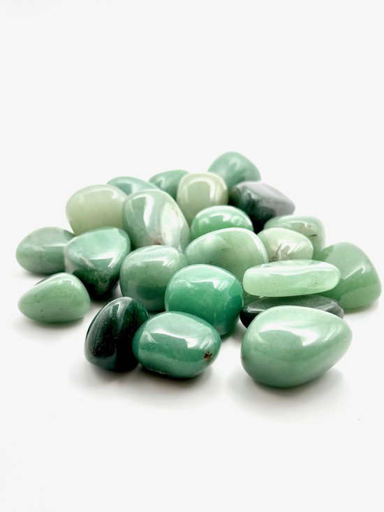 Een hoop gepolijste, groene Aventurijn edelstenen in verschillende tinten groen op een witte achtergrond.