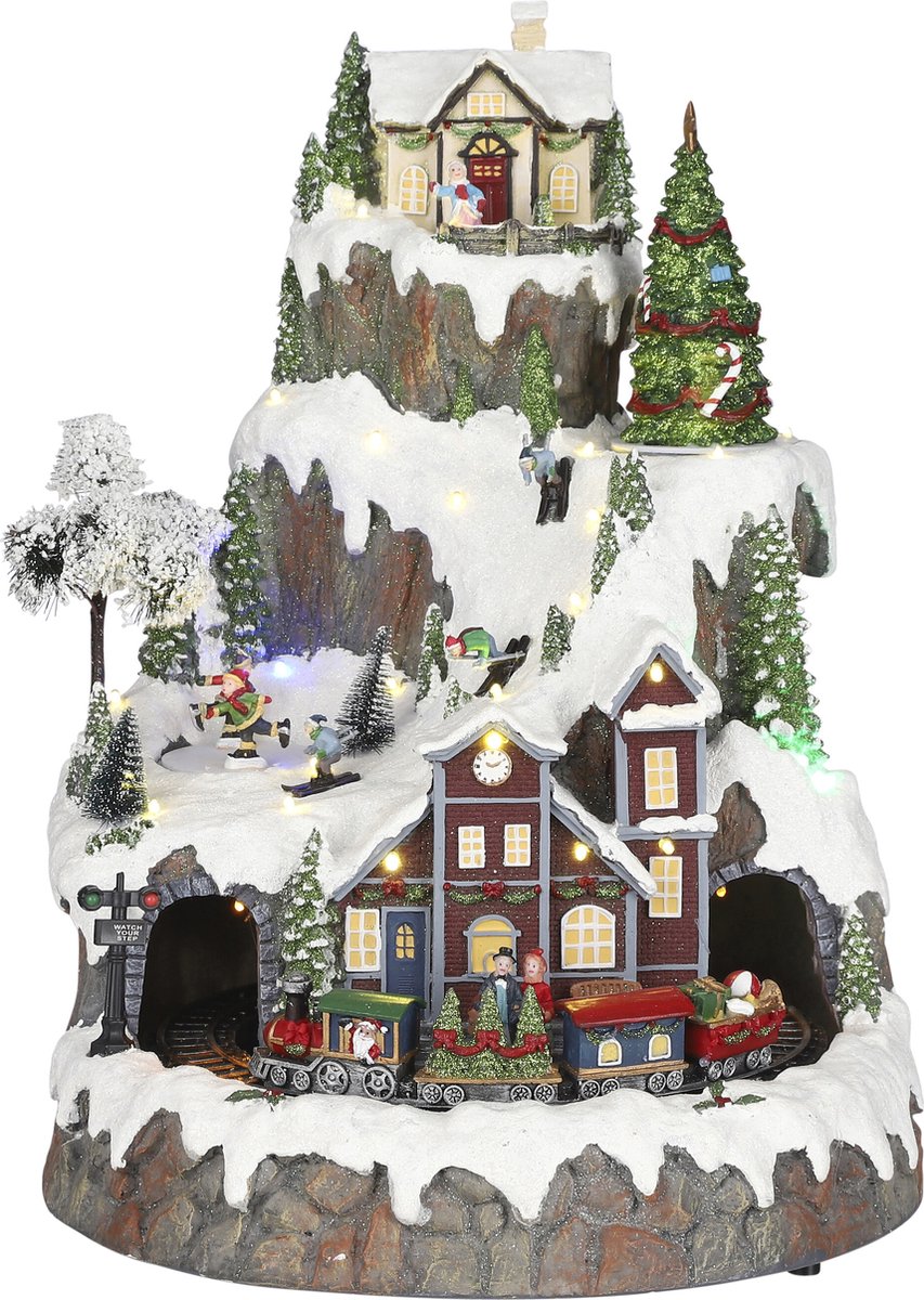 Miniatuur kerstdorp met trein en berglandschap.