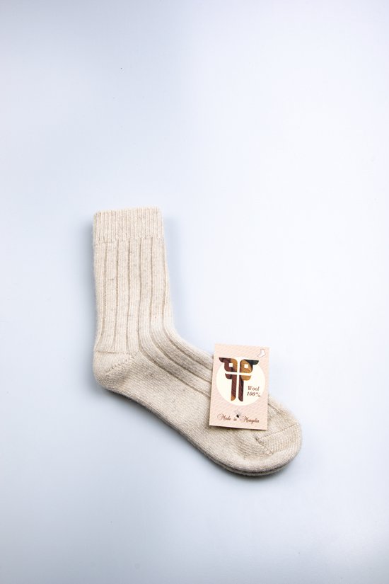 Crème wollen sokken met ribbels, met een kaartje met "Wool 100% Made in Mongolia".