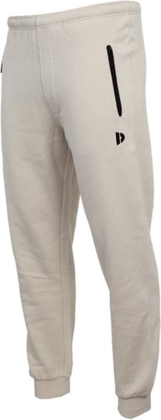 Zijkant van een beige joggingbroek met een ritsvak en een klein zwart logo.