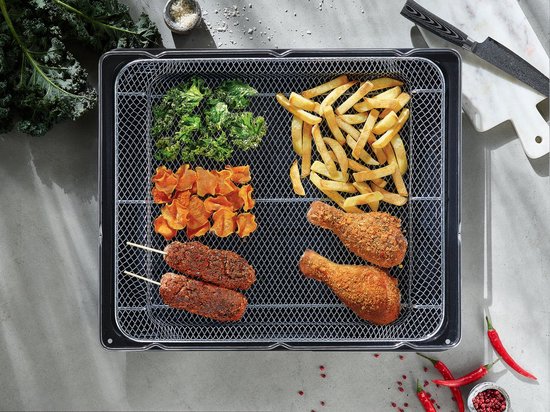 Grillmand vol met frietjes, kip, zoete aardappelschijfjes en groenten.