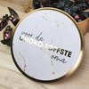 Boîte dorée avec couvercle marbré portant l'inscription 'voor de CHOKO-TOFFSTE oma'. Remplie de chocolat.
