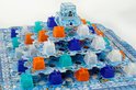 Bordspel 'Nunatak De IJstempel' met piramide in het midden en oranje, paarse, turkooizen en witte torens op het blauwe, ijzige veld.