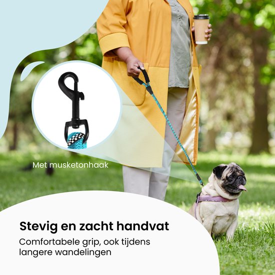 Vrouw met hond op een grasveld met een riem met musketonhaak