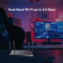 TP-Link Archer BE230 router op een bureau in een gaming kamer, met de tekst "Dual-Band Wi-Fi up to 3.6 Gbps".
