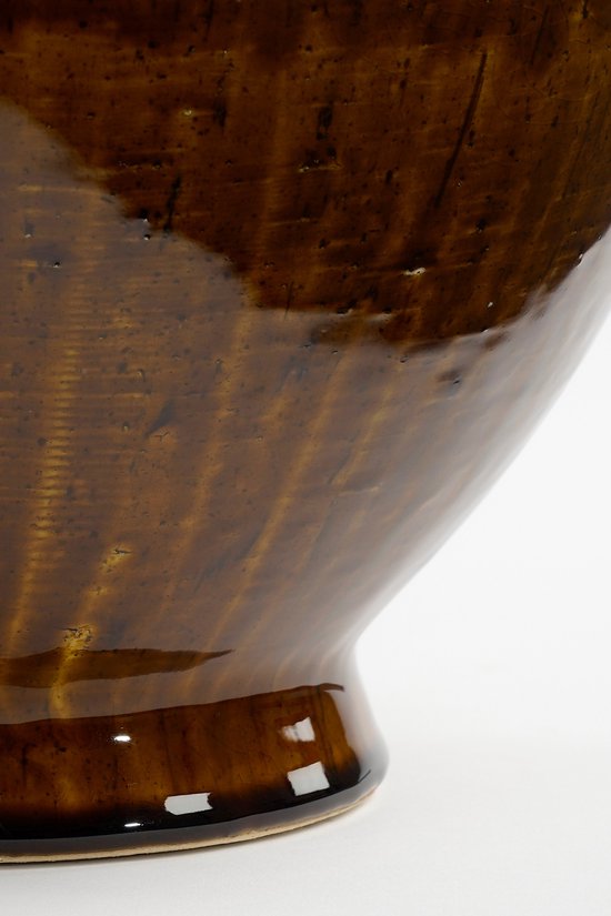 Onderkant van een glanzende, bruine keramische vaas met verticale ribbels en een brede voet.