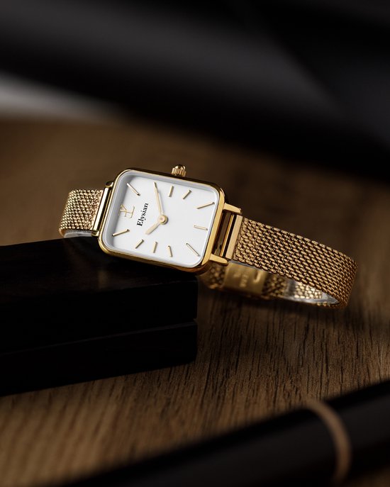 Gouden rechthoekig horloge met mesh band, rustend op een zwarte doos.