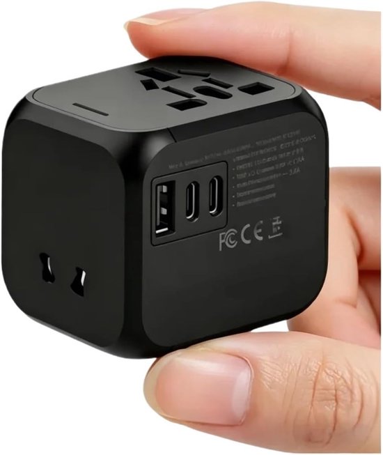 Zwarte universele reisadapter met meerdere stopcontacten en USB-poorten, vastgehouden in een hand.