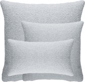Drie lichtgrijze teddy bouclé kussens in de maten 30x50 cm, 45x45 cm en 60x60 cm, gestapeld.
